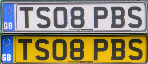 A pair of number plates. The upper plate has a white background and black letters (TS08 PBS) and a vertical blue stripe on the left-hand side with the EU stars and the text GB. The lower plate has a yellow background and the same black letters, plus the same blue stripe on the left hand side.